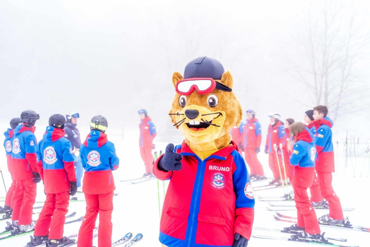 Gruppenfoto-Skilehrerteam-mit-Maskottchen-Bruno